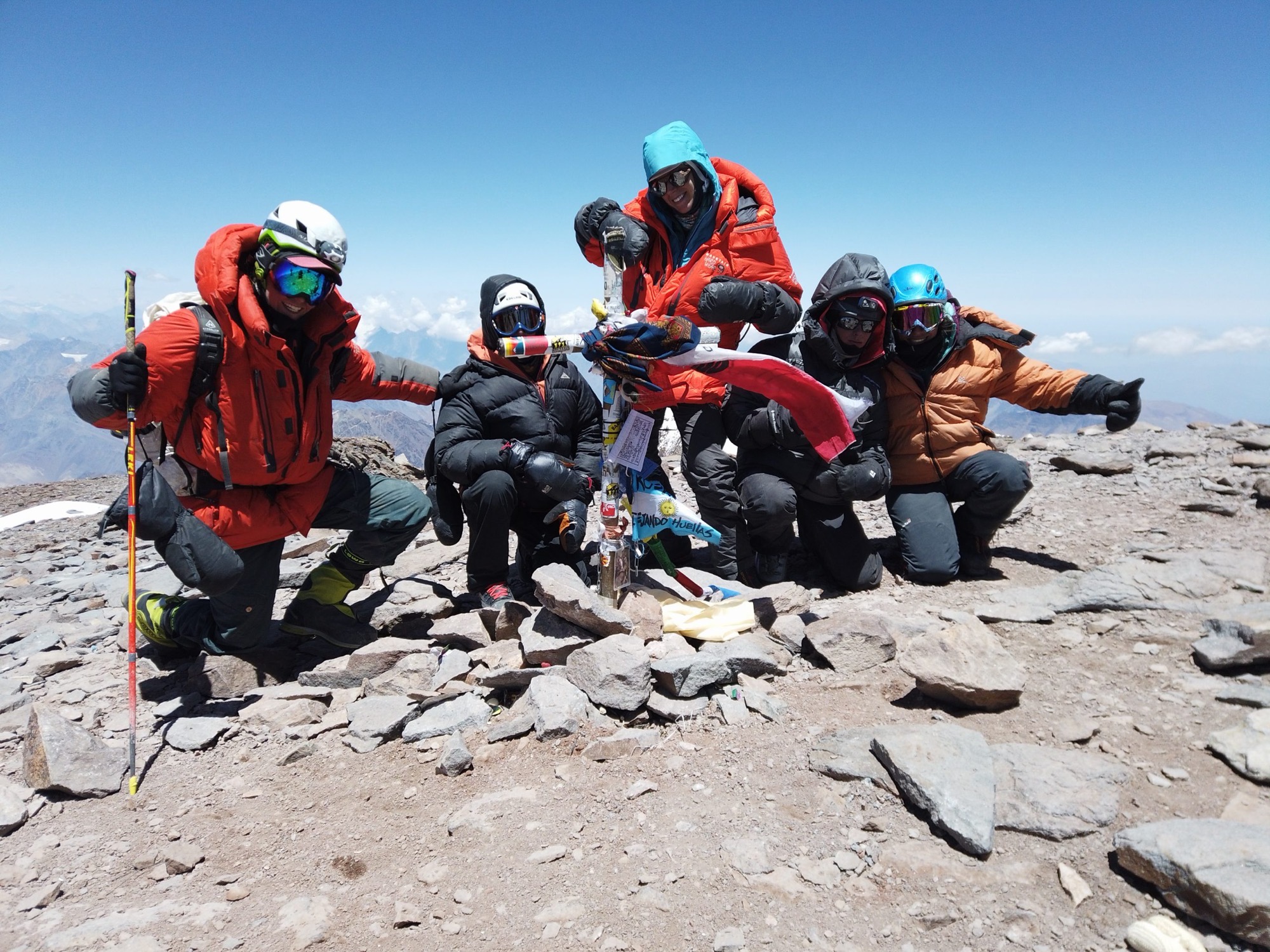 An AWE team celebrating together on the summit of Aconcagua
