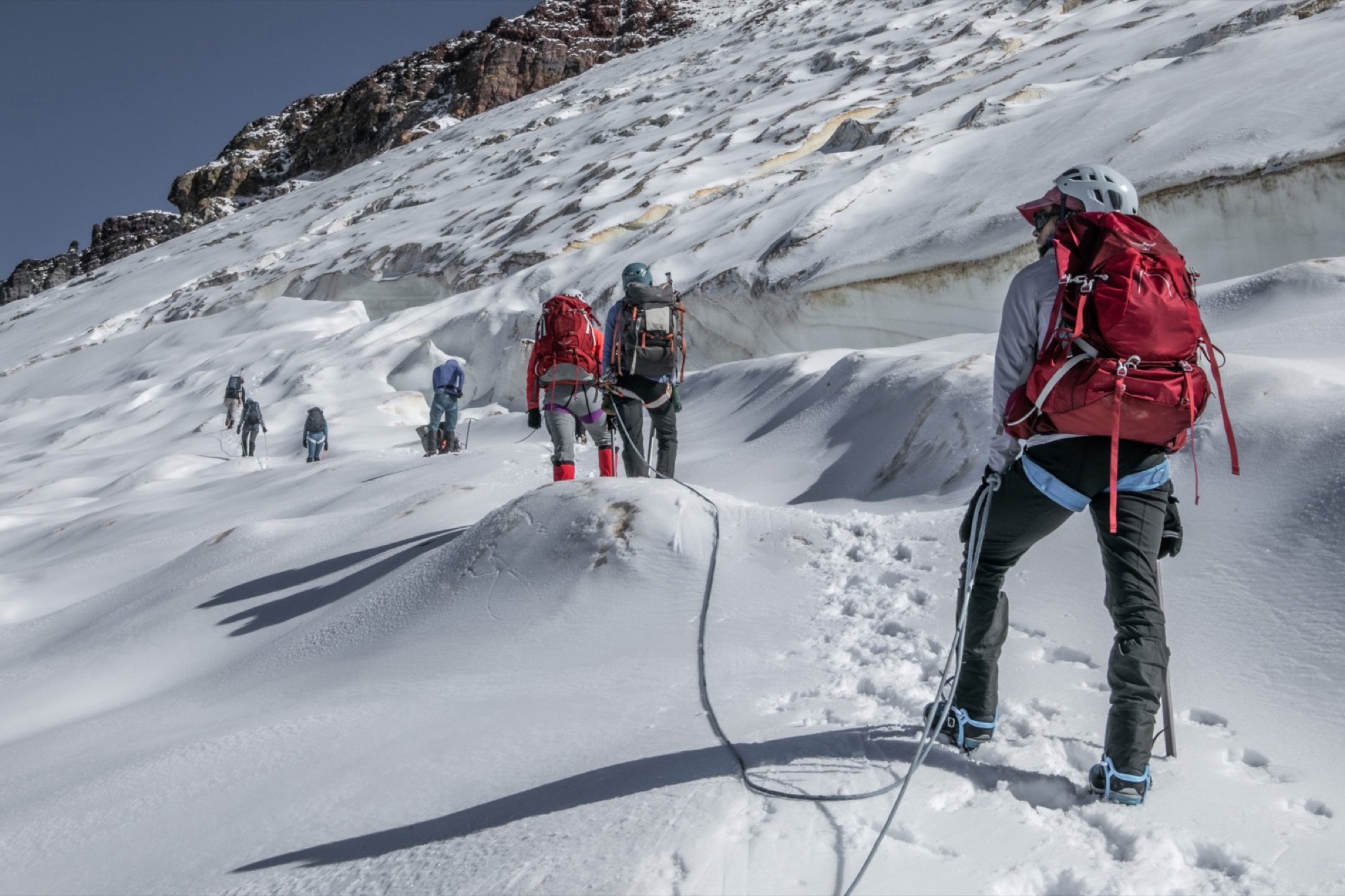 A rope team climbing a snow slope on Mount Baker